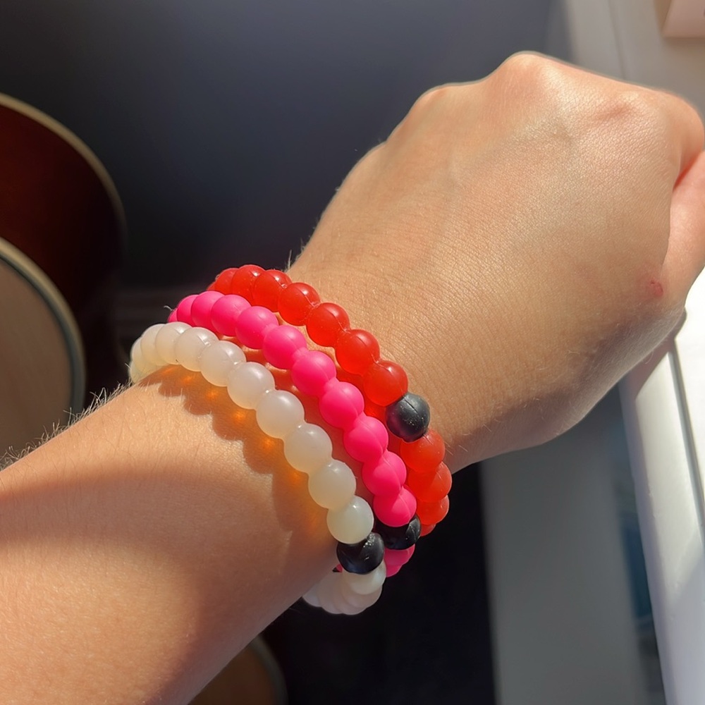 Lokai bracelets: red, clear, and pink